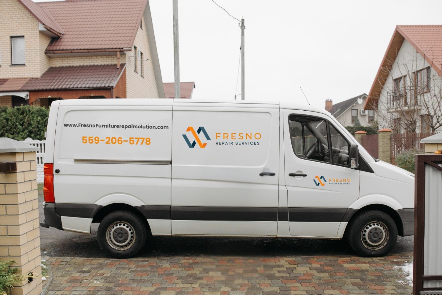 Delivery van with Fresno Solar Solutions logo parked on a residential street in front of a house.