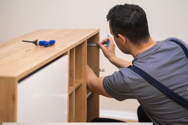 A person assembling a wooden furniture piece, using tools, with a screwdriver placed on the surface nearby.
