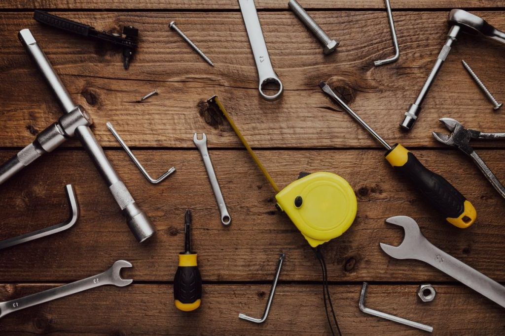 Assorted tools displayed on a wooden table, featuring a clear area for potential text or other elements.